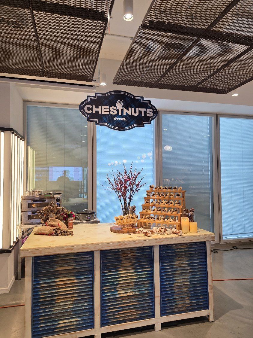 עמדת ערמונים חמים עם שלט Chestnuts, מדף קונוסים ונרות, באירוע של earnix